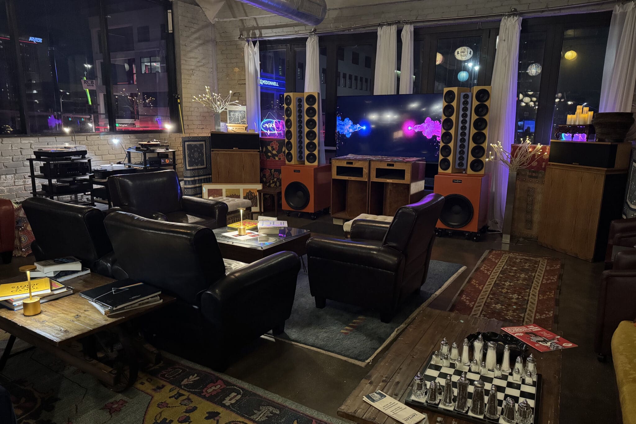 Featured Business June 2026 SoundBar - interior of a music listening room with leather chairs, rugs, speakers and other music paraphernalia.